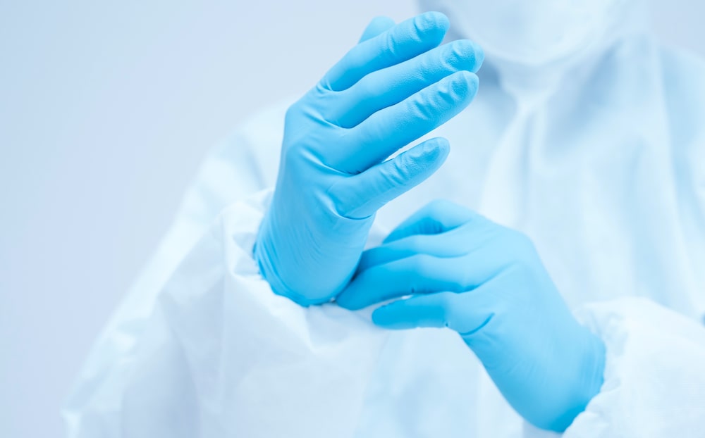 Person donning surgical gloves